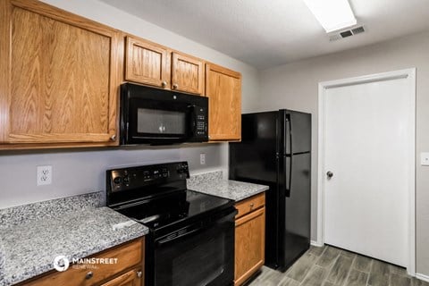 a kitchen with black appliances and granite counter tops