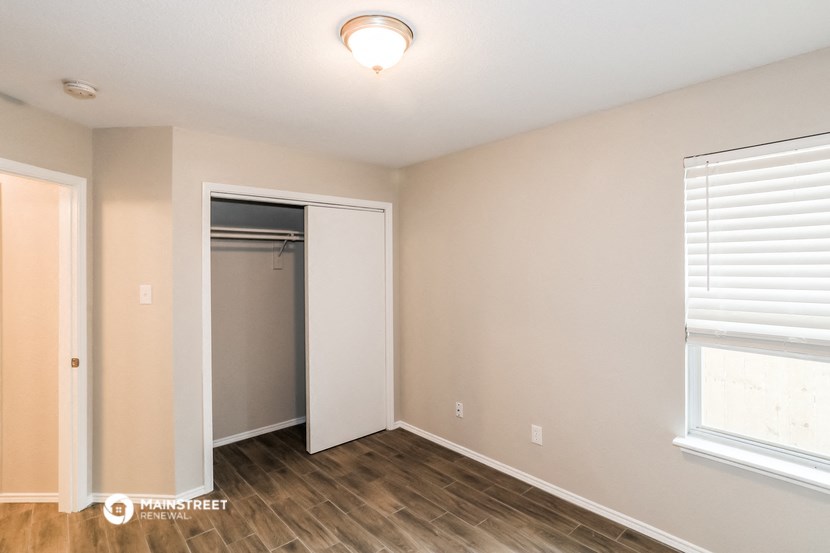 an empty room with a closet and a window