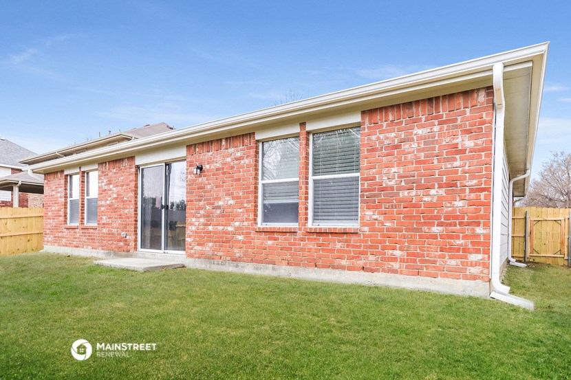 a brick house with a yard and a lawn