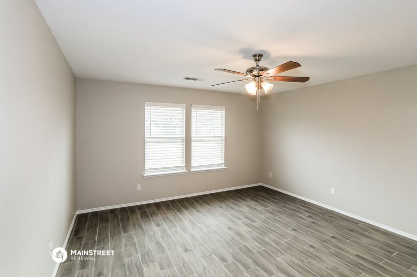 an empty room with a ceiling fan and a window
