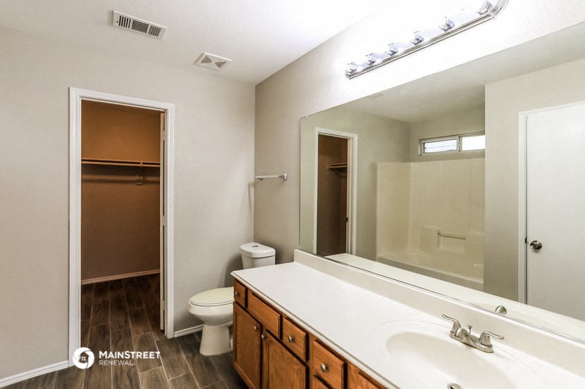 a bathroom with a large mirror and a sink and a toilet