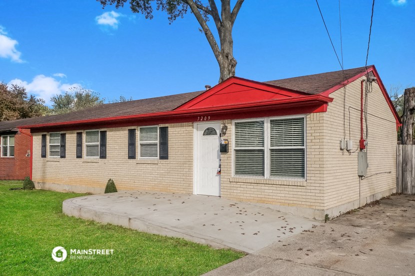 a small white house with a red roof and a sidewalk