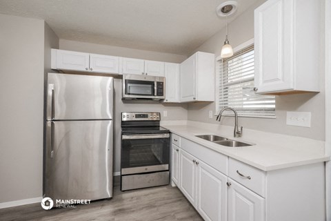 a kitchen with stainless steel appliances and white cabinets