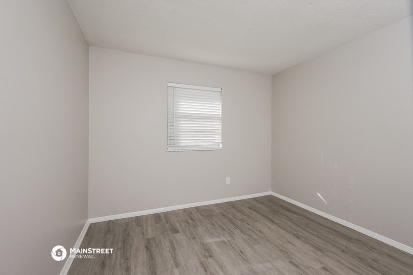 an empty room with white walls and wooden floors