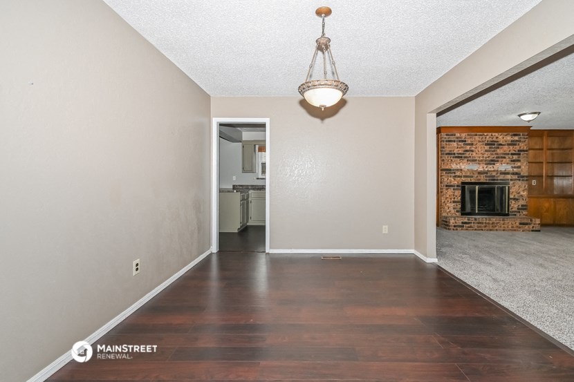 an empty living room with a fireplace and hardwood floor