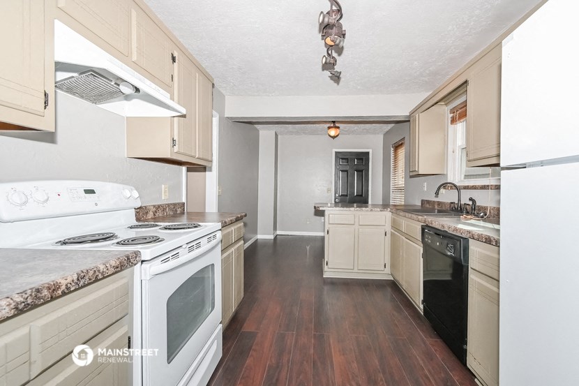 a kitchen with white appliances and wood flooring