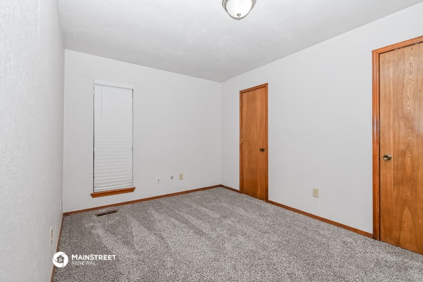 a bedroom with carpet and a door to a closet