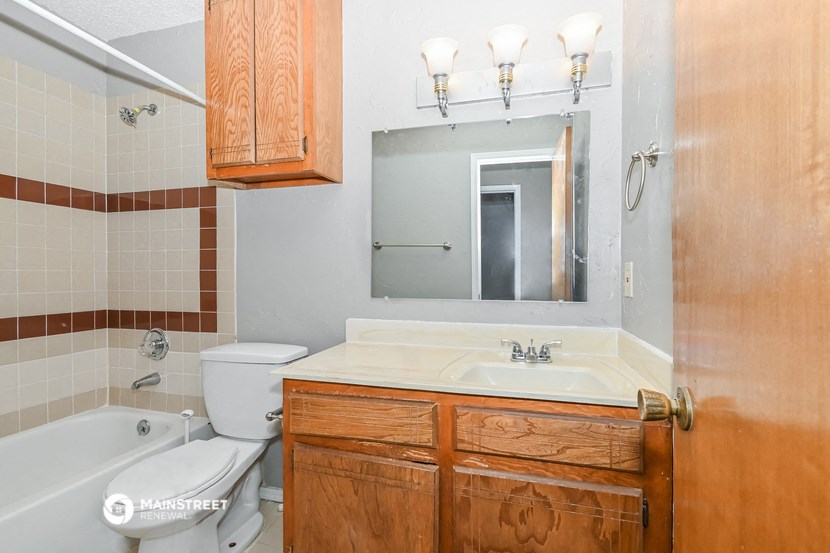 a bathroom with a sink toilet and tub and a mirror