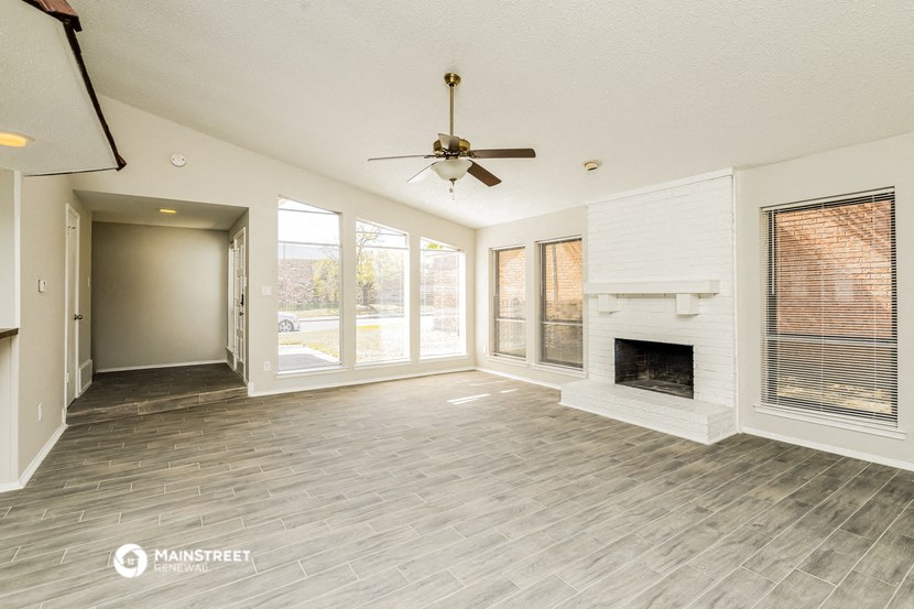 a living room with a fireplace and a ceiling fan
