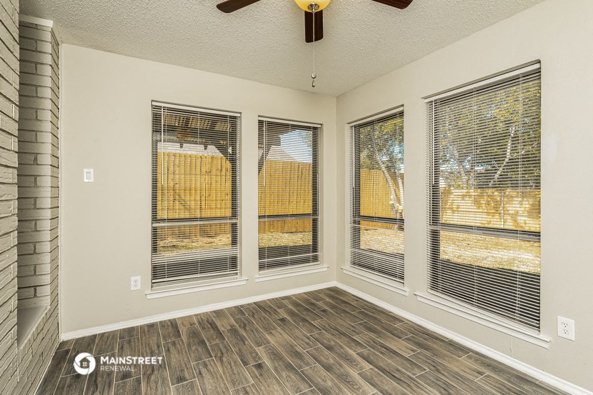 the living room of a new home with windows and a ceiling fan