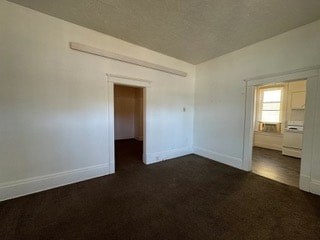 A room with a brown carpet and white walls.