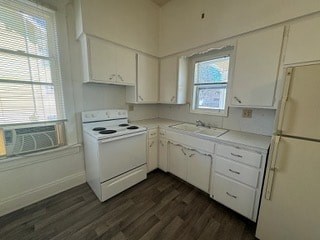 A kitchen with white appliances and wooden floors.
