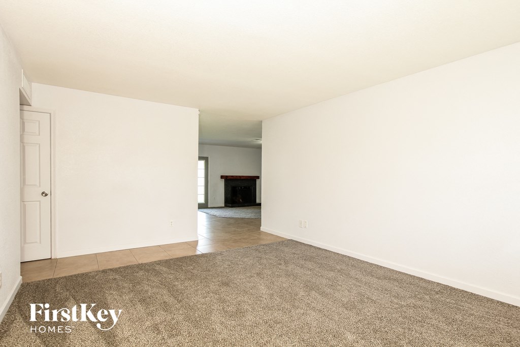 an empty living room with white walls and a carpet