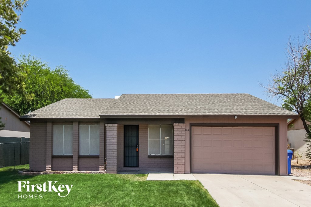 a small brick house with a driveway and a garage door