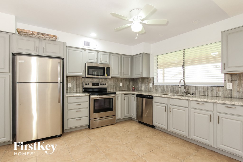 a large kitchen with stainless steel appliances and white cabinets