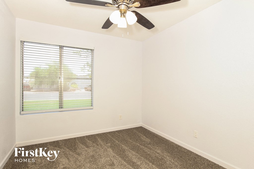 a bedroom with a ceiling fan and a window