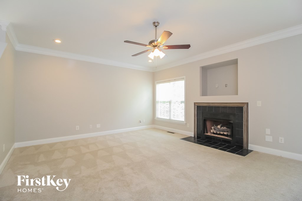 a living room with a fireplace and a ceiling fan