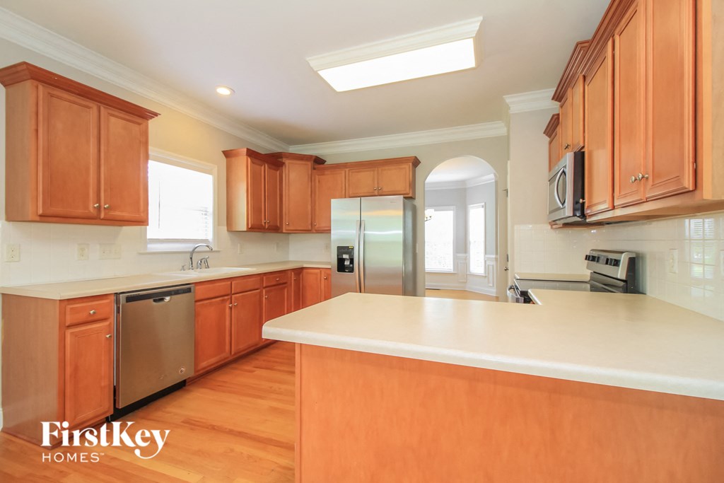a kitchen with wooden cabinets and a white counter top
