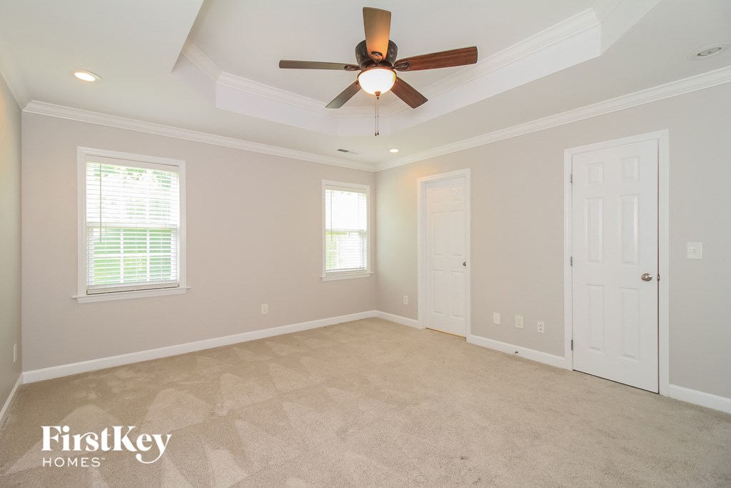 a living room with a ceiling fan and a white door