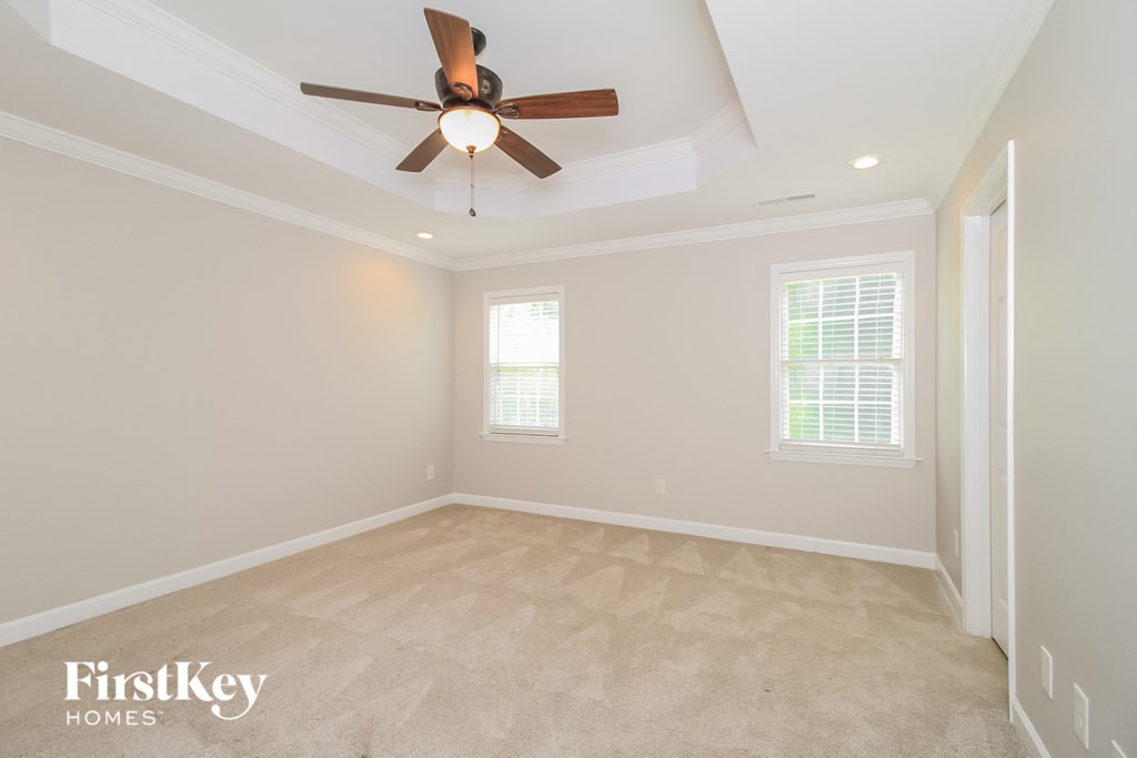 an empty living room with a ceiling fan