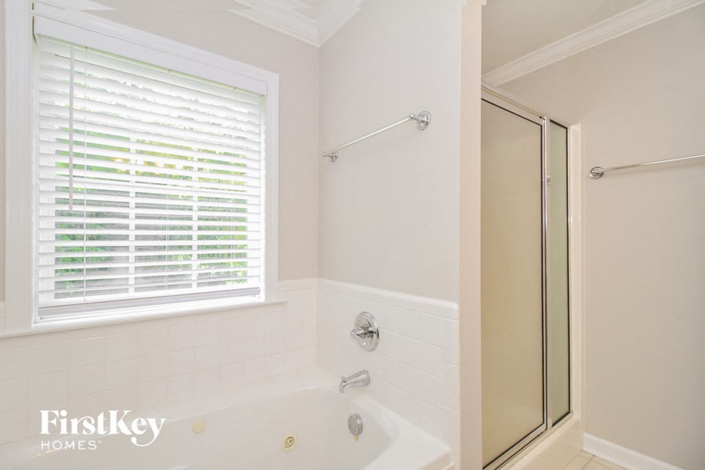 a bathroom with a tub and a shower and a window