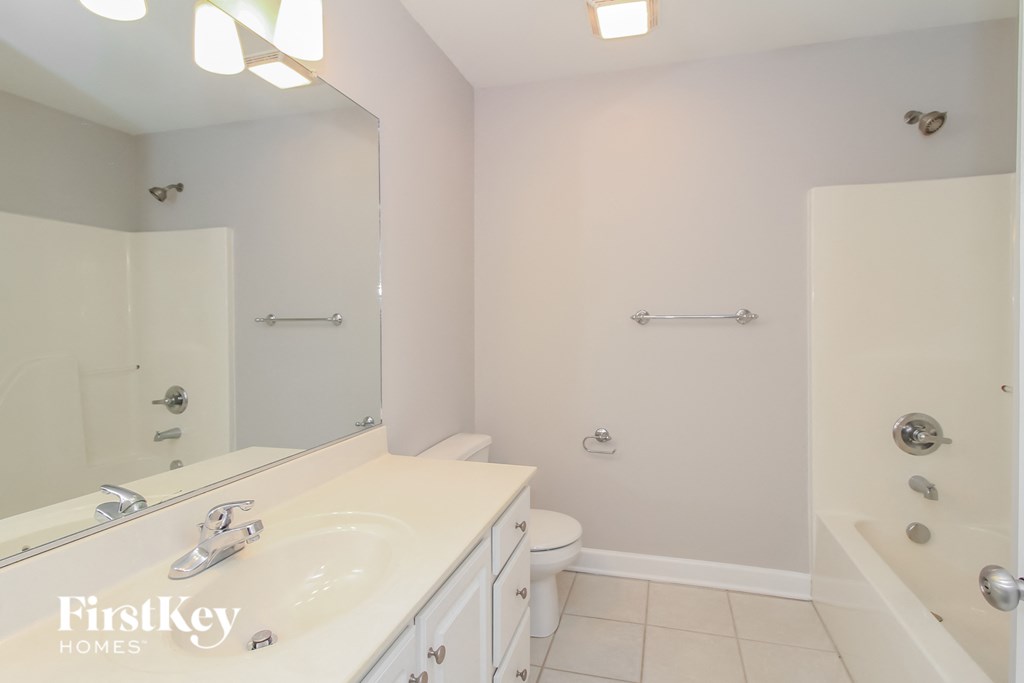 a bathroom with a white sink and a toilet and a mirror
