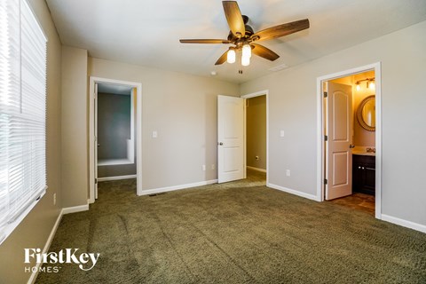 a living room with carpet and a ceiling fan