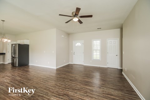 A spacious room with a ceiling fan and wooden flooring.