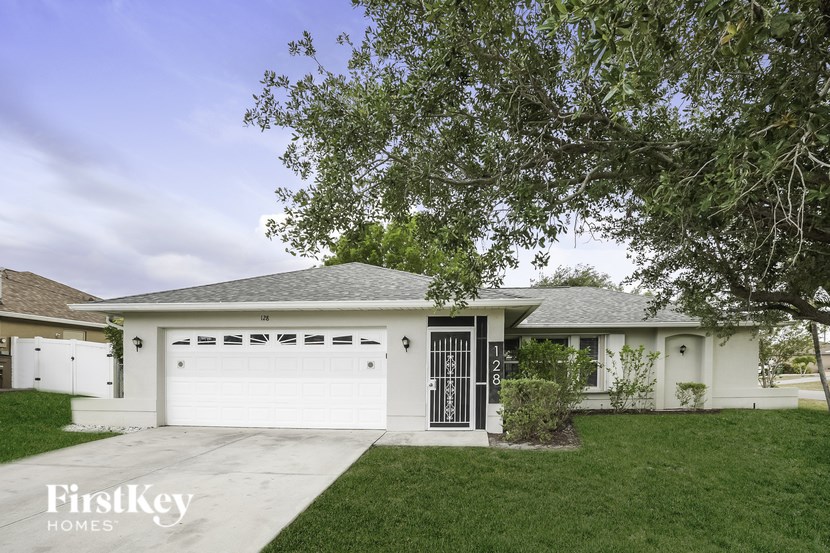 A house with a white garage door and a black gate.