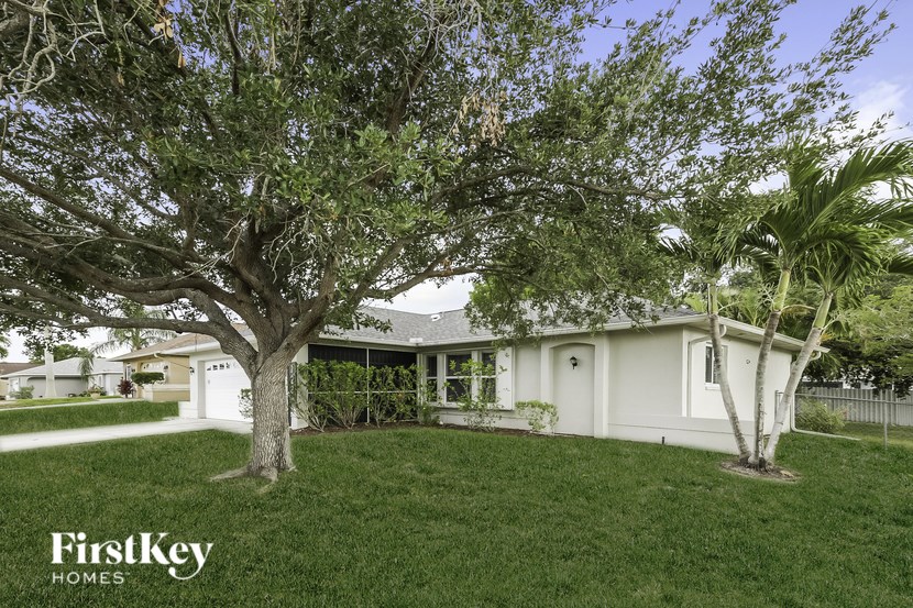 A tree in front of a house with the words "FirstKey Homes" on the bottom.