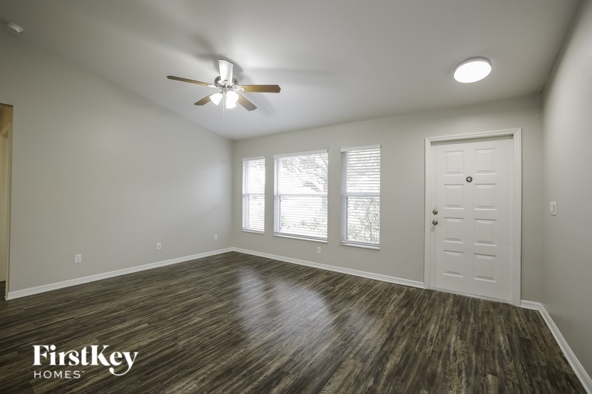 A room with a wooden floor and a ceiling fan.