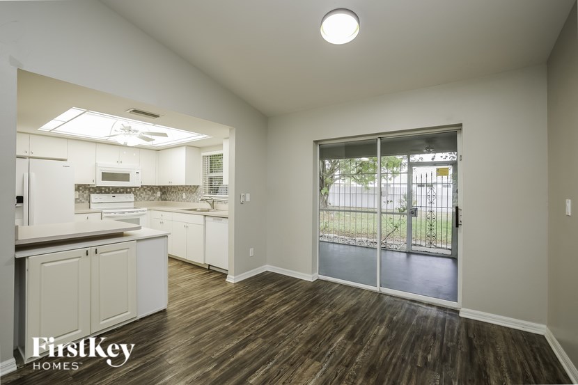 A kitchen with a sliding glass door leading to a backyard.