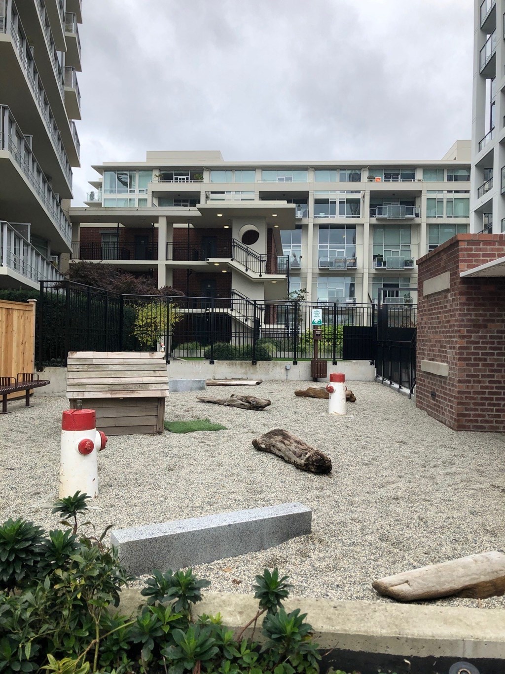a courtyard with a fire hydrant in front of an apartment building #victoria #rentals #affordable #apartments #bed