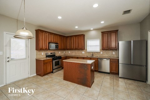 A kitchen with wooden cabinets and a stainless steel refrigerator.