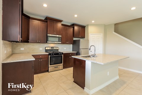 A kitchen with brown cabinets and a white island.