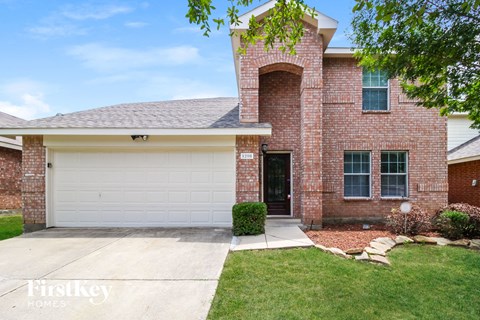 A brick house with a garage door that says "Firstkey Homes".