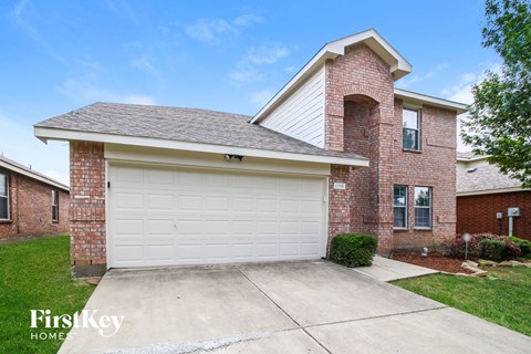 A brick house with a garage door that says FirstKey Homes.