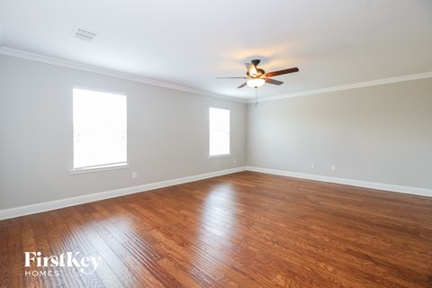 A room with wooden floors and a ceiling fan.