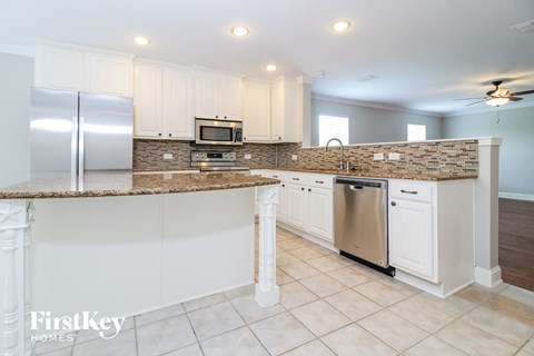 A kitchen with a refrigerator, microwave, and dishwasher.