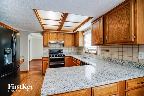 A kitchen with wooden cabinets and a granite countertop.