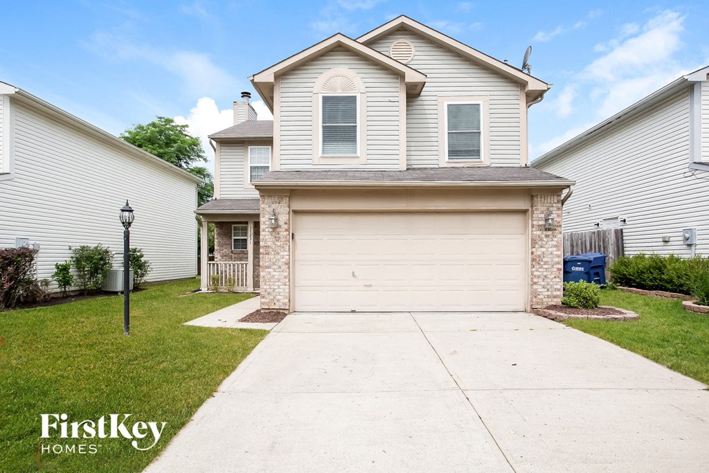 a white house with a white garage door and a sidewalk