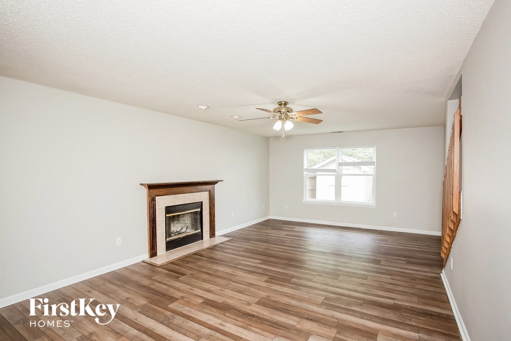 a living room with a fireplace and a ceiling fan