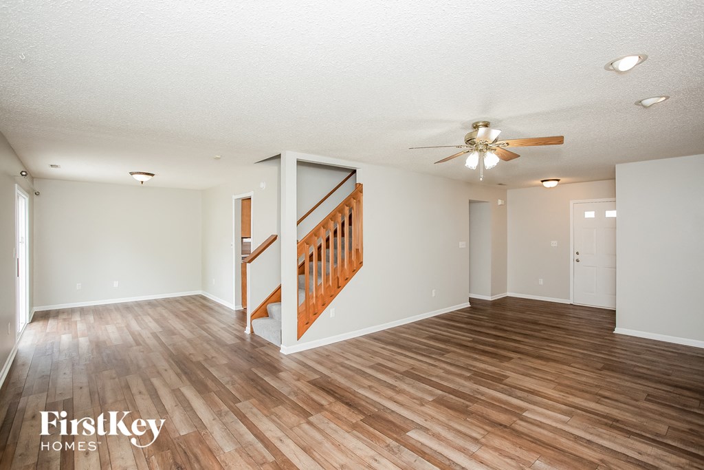 a living room with a wooden floor and a ceiling fan