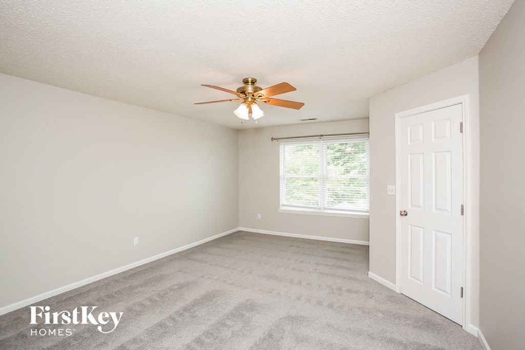 a bedroom with carpet and a ceiling fan