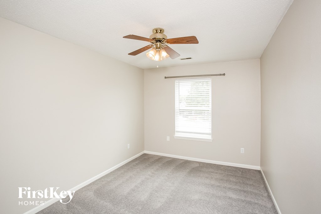 a bedroom with a ceiling fan and a window