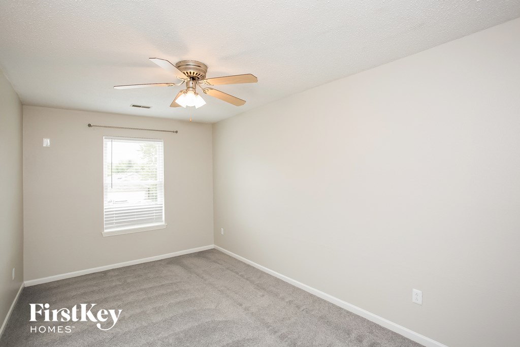 a bedroom with carpet and a ceiling fan