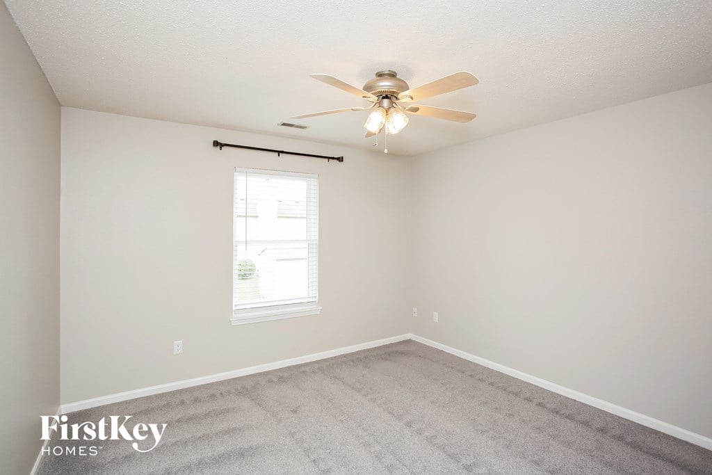 a bedroom with a ceiling fan and a window