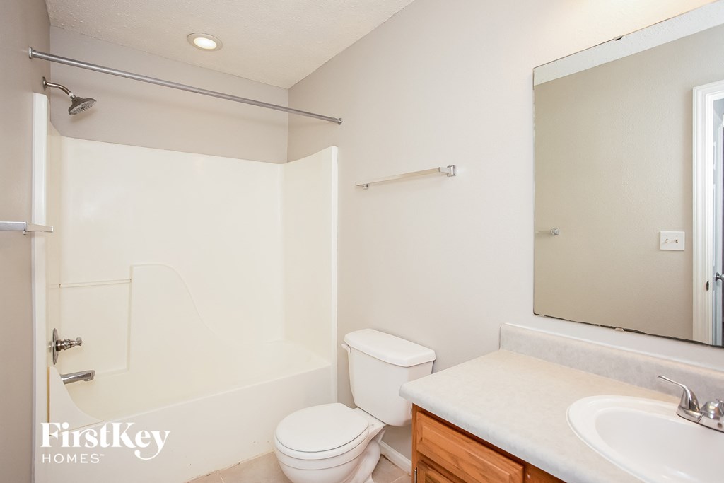 a bathroom with a sink toilet and a mirror