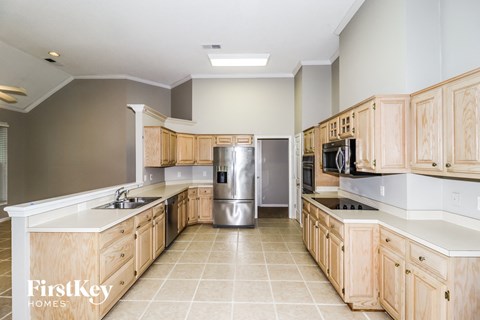 A kitchen with wooden cabinets and a stainless steel refrigerator.