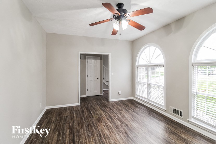 the living room of an empty house with a ceiling fan
